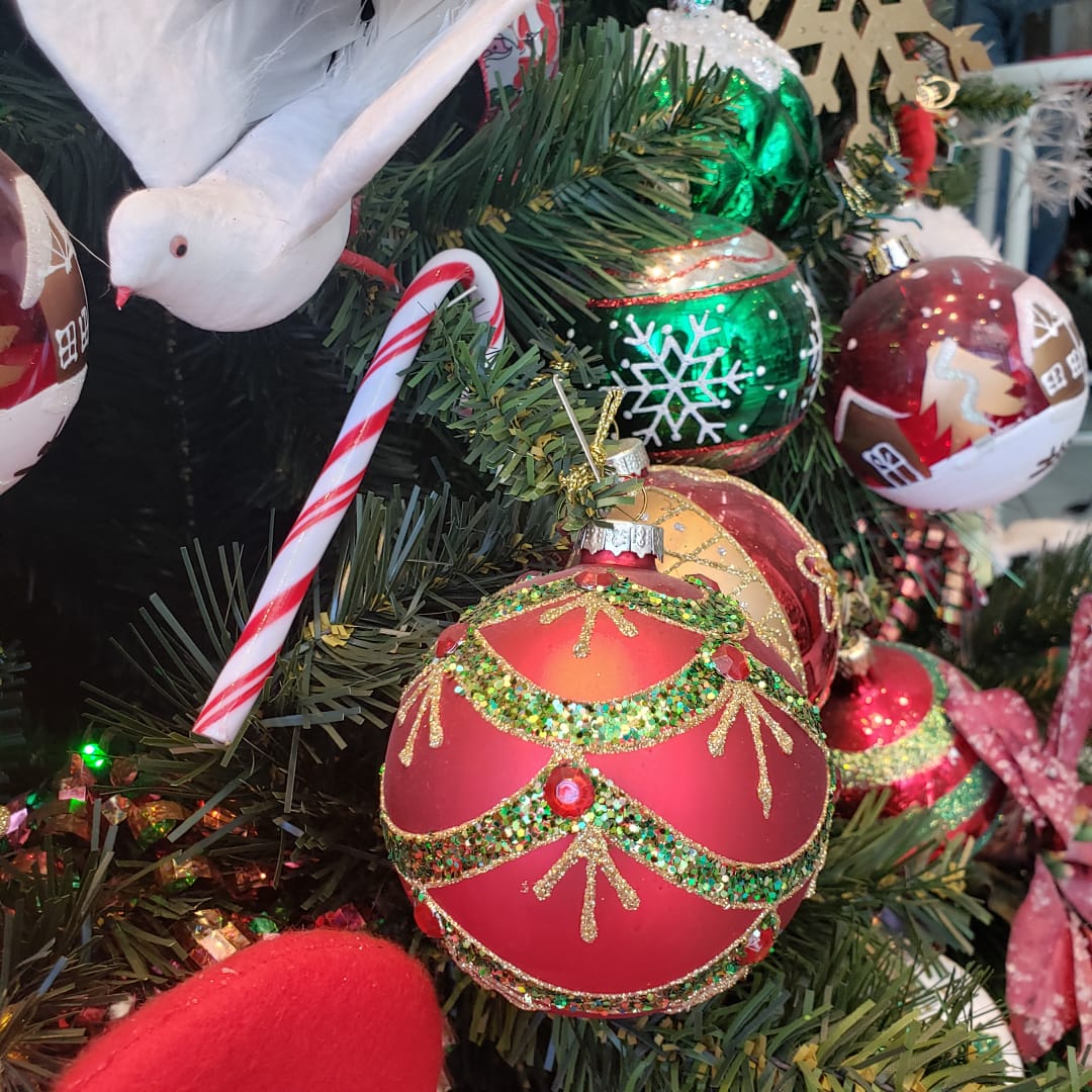 Globos rojos y verdes decorados en un árbol de Navidad